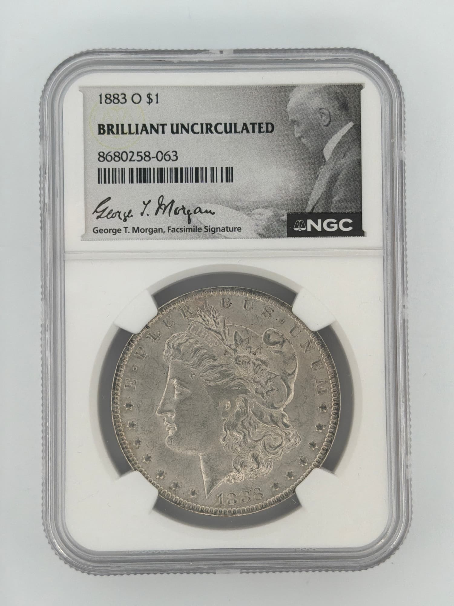 1883-O Morgan Silver Dollar NGC Brilliant Uncirculated obverse in slab with George T. Morgan facsimile signature label